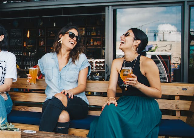 A couple of friends laughing and drinking